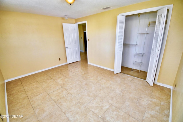 unfurnished bedroom featuring a closet and a textured ceiling