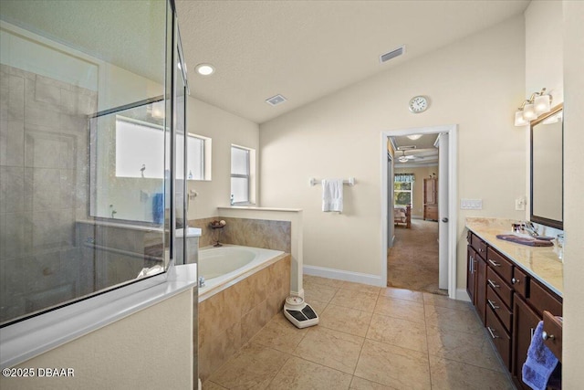 bathroom featuring visible vents, vaulted ceiling, a shower stall, a bath, and double vanity