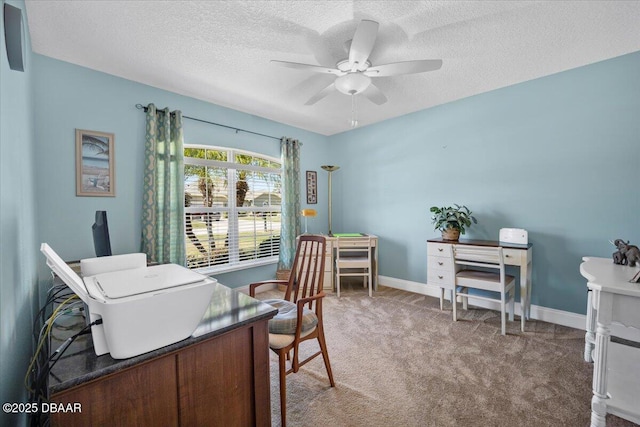 carpeted home office with a textured ceiling, ceiling fan, and baseboards