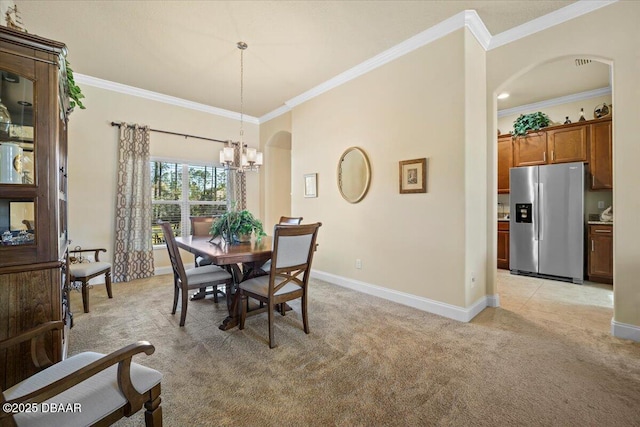 dining space with light carpet, baseboards, a chandelier, and arched walkways