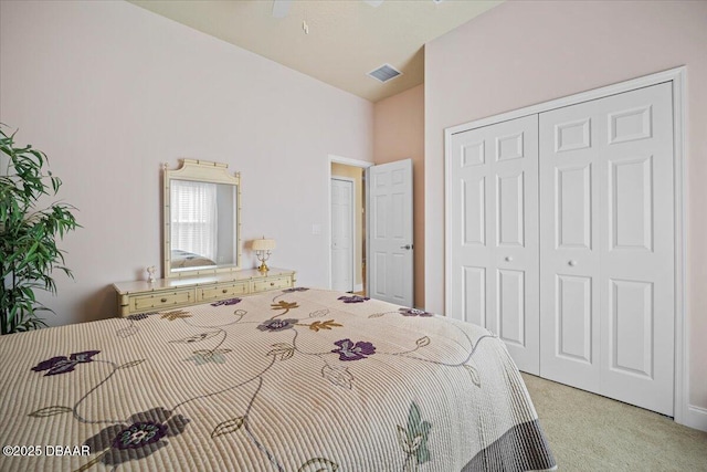 bedroom with high vaulted ceiling, visible vents, a closet, and light colored carpet