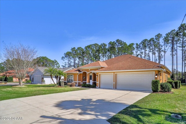 mediterranean / spanish home with a garage, a front yard, driveway, and stucco siding