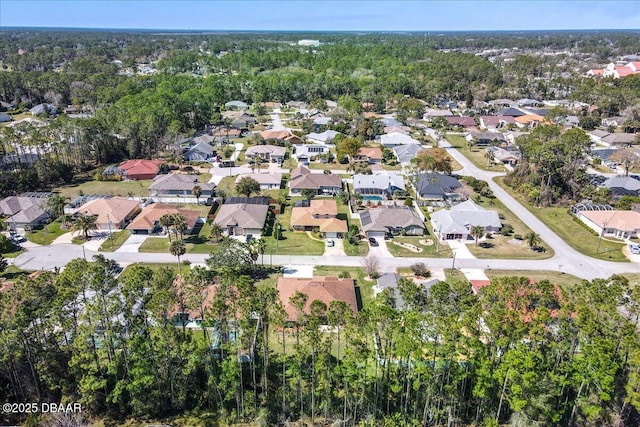 drone / aerial view featuring a residential view and a wooded view