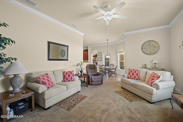 carpeted living room featuring ceiling fan, ornamental molding, and visible vents