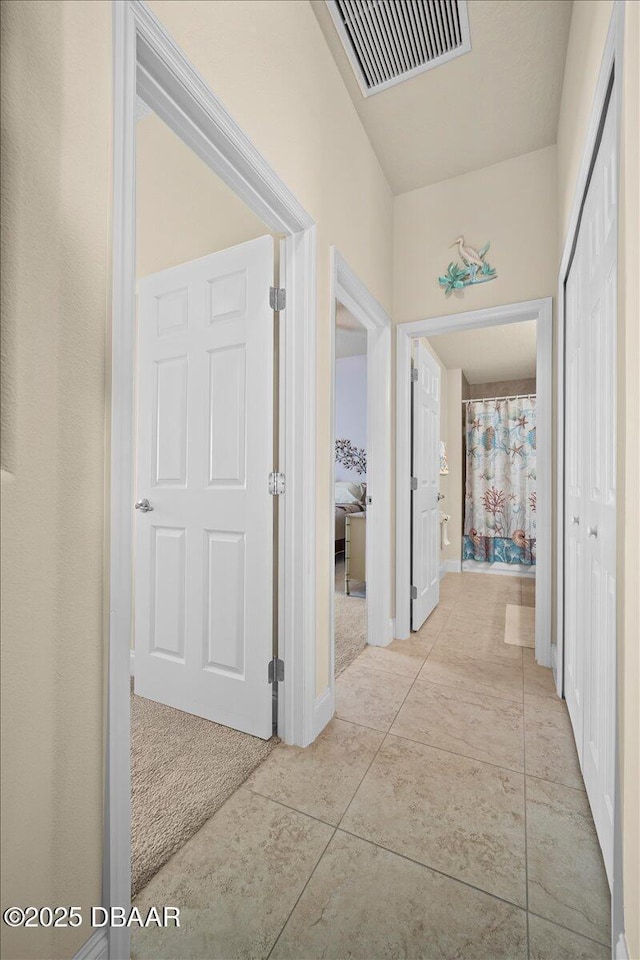 hallway with visible vents and light tile patterned flooring