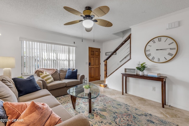 living room with ceiling fan, crown molding, light tile patterned floors, and a textured ceiling