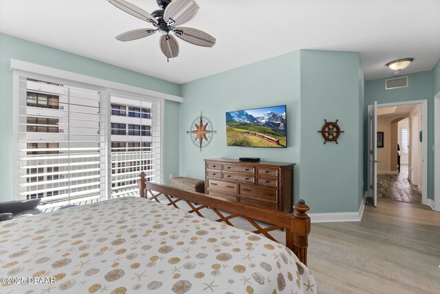 bedroom featuring ceiling fan, light hardwood / wood-style flooring, and multiple windows