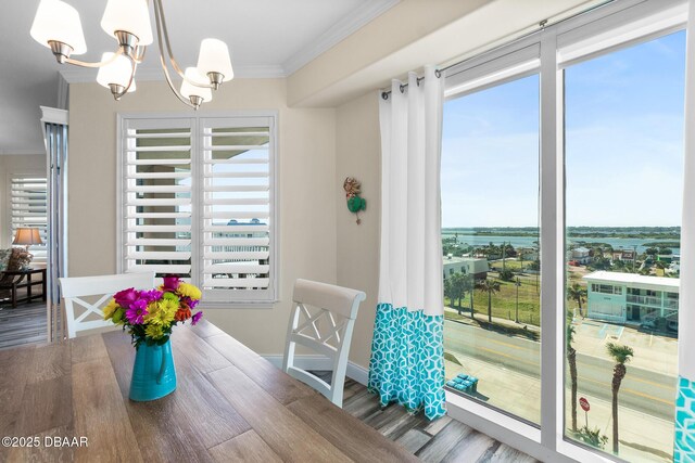 dining space featuring an inviting chandelier, crown molding, and hardwood / wood-style floors