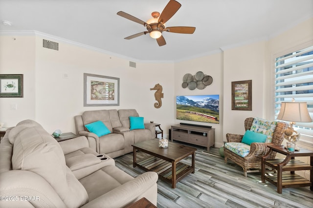 living room with ceiling fan, light wood-type flooring, and ornamental molding