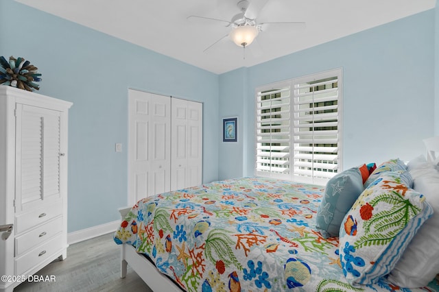 bedroom with ceiling fan, light hardwood / wood-style floors, and a closet