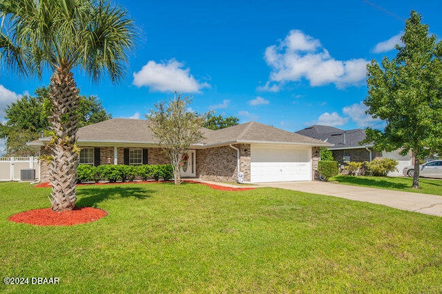 ranch-style house featuring a front lawn, a garage, and central AC unit