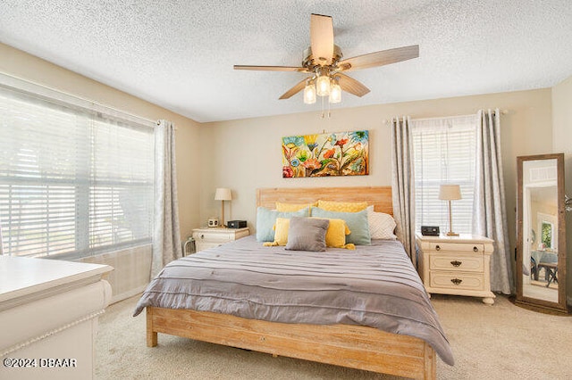 bedroom featuring ceiling fan, multiple windows, and a textured ceiling