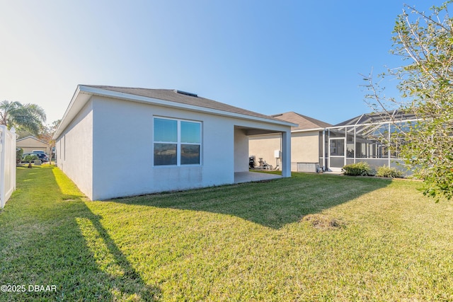 back of property with a lanai, a yard, and a patio