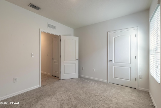 unfurnished bedroom featuring light colored carpet