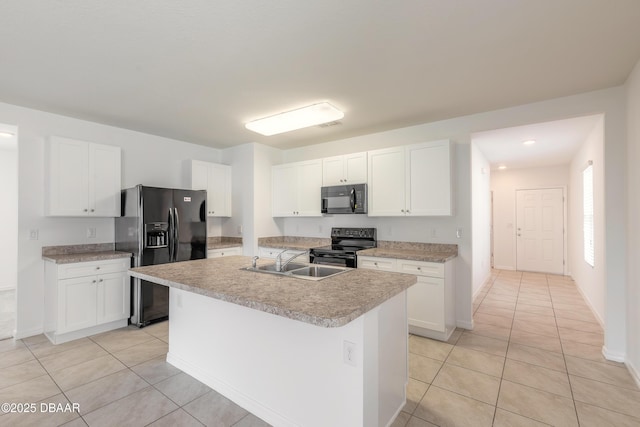 kitchen with sink, white cabinets, black appliances, and an island with sink