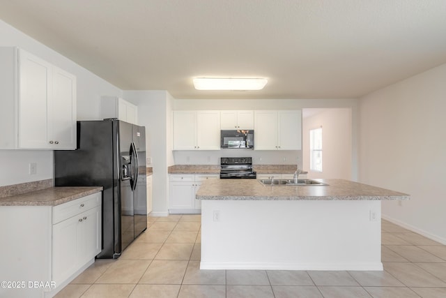 kitchen with black appliances, an island with sink, light tile patterned floors, sink, and white cabinetry