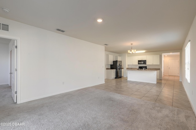 unfurnished living room with light carpet and a notable chandelier