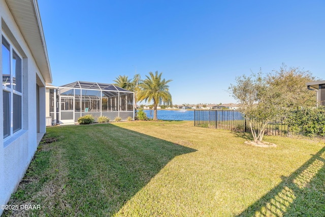 view of yard with a lanai and a water view