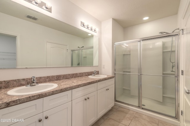 bathroom featuring vanity, a shower with door, and tile patterned flooring