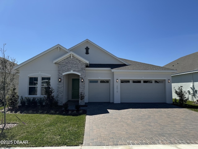 single story home with stucco siding, a front lawn, driveway, a shingled roof, and a garage