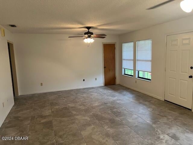 spare room with a textured ceiling and ceiling fan