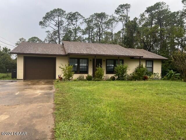 single story home with a garage and a front lawn