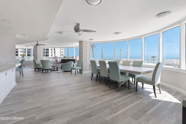 dining area featuring a textured ceiling, light hardwood / wood-style floors, and ceiling fan