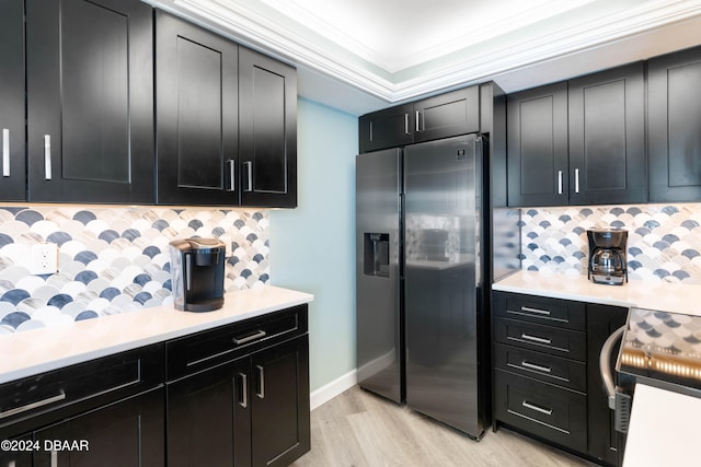 kitchen with crown molding, light hardwood / wood-style floors, backsplash, and stainless steel fridge with ice dispenser