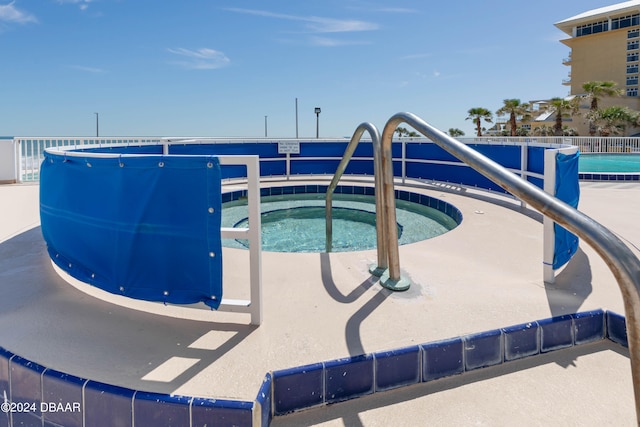 view of swimming pool with a hot tub