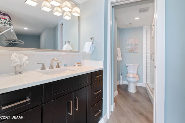 bathroom with a shower with door, wood-type flooring, toilet, and vanity