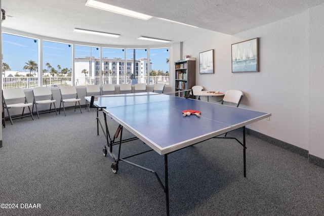 game room with a textured ceiling and carpet flooring