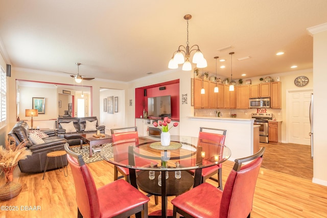 dining room featuring crown molding, ceiling fan with notable chandelier, and light hardwood / wood-style flooring