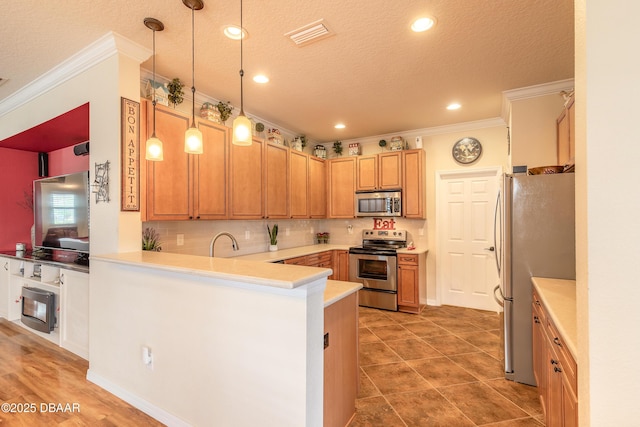 kitchen featuring sink, crown molding, hanging light fixtures, kitchen peninsula, and stainless steel appliances