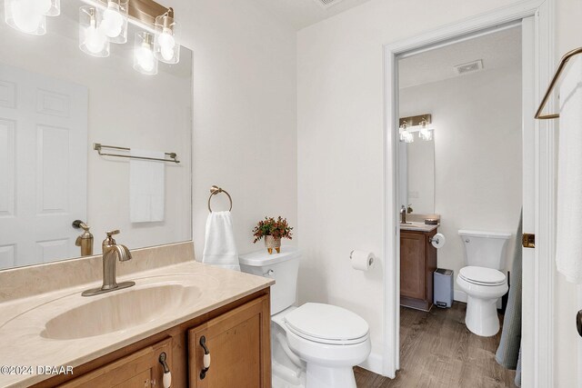 bathroom featuring hardwood / wood-style floors, vanity, and toilet