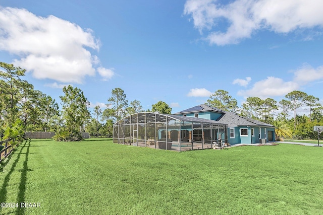 back of property featuring a swimming pool, a patio, a yard, and glass enclosure