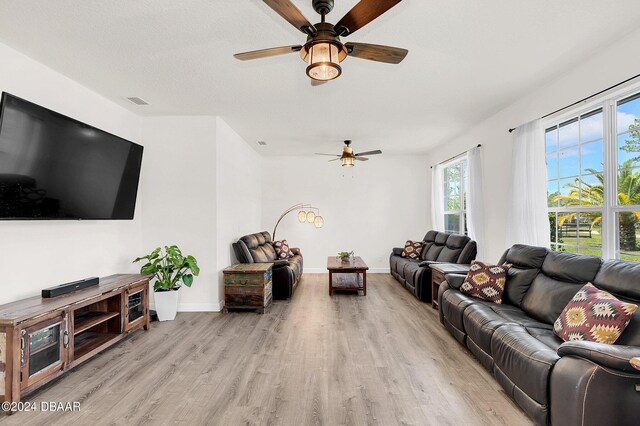 living room featuring light hardwood / wood-style flooring and ceiling fan