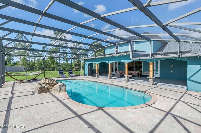 view of pool with a patio, a yard, and a lanai