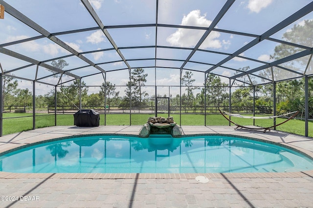 view of swimming pool with glass enclosure and a lawn