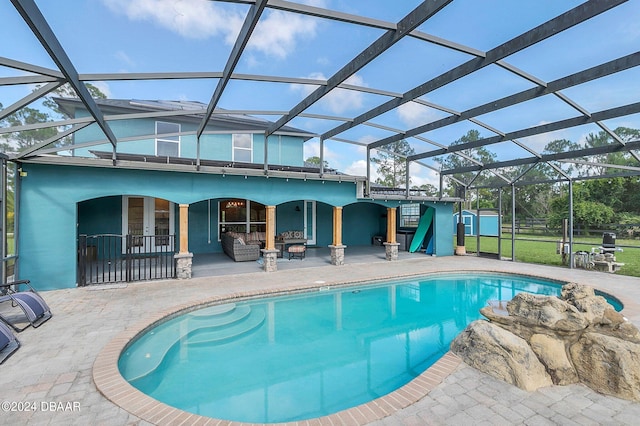 view of pool featuring glass enclosure and a patio