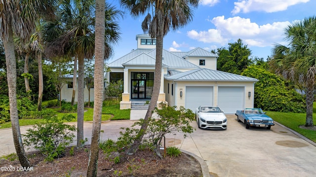 200 John Anderson Dr, Ormond Beach, FL 32176 - view of front of house with a standing seam roof, concrete driveway, an attached garage, and metal roof