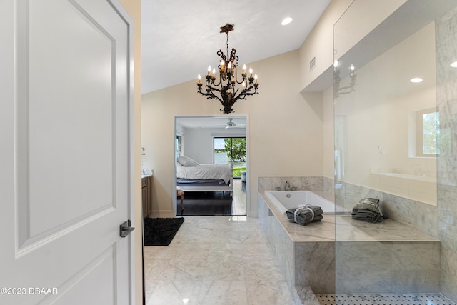 bathroom featuring tiled bath, ceiling fan with notable chandelier, and vaulted ceiling