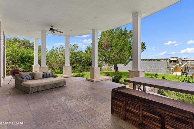 view of patio with a water view and ceiling fan