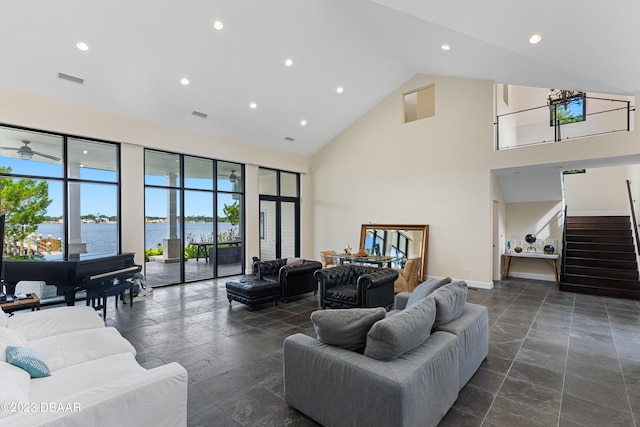 living room featuring high vaulted ceiling and a water view