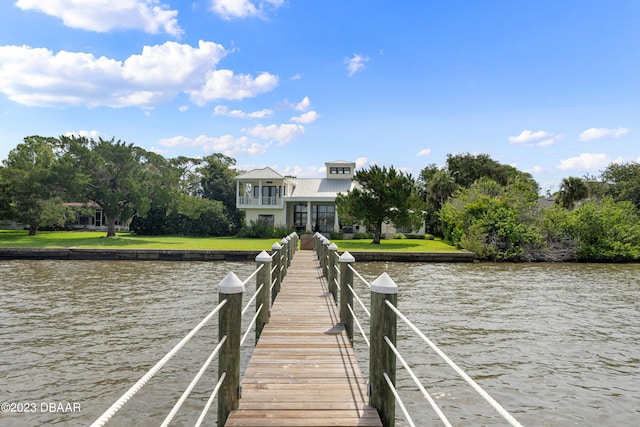 view of dock featuring a lawn and a water view