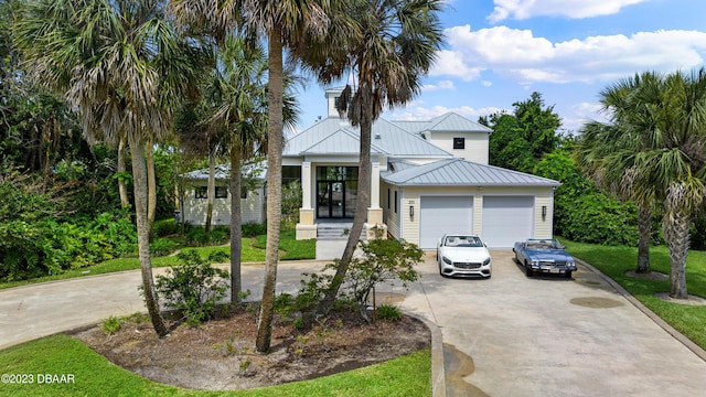 200 John Anderson Dr, Ormond Beach, FL 32176 - view of front of property with concrete driveway, a standing seam roof, an attached garage, metal roof, and a front lawn