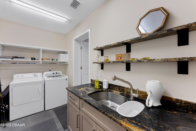 washroom featuring cabinets, sink, and independent washer and dryer