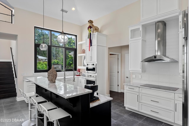 200 John Anderson Dr, Ormond Beach, FL 32176 - kitchen with wall chimney exhaust hood, decorative backsplash, white cabinetry, recessed lighting, and a towering ceiling
