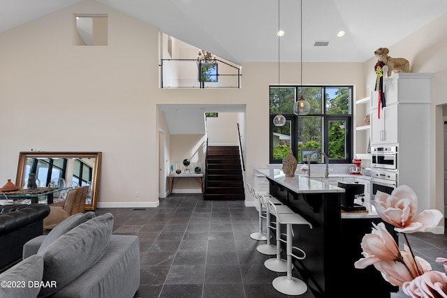 dining space featuring sink and high vaulted ceiling