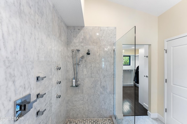 bathroom featuring hardwood / wood-style flooring and a tile shower