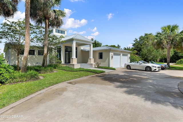 200 John Anderson Dr, Ormond Beach, FL 32176 - view of front facade with a porch, metal roof, a detached garage, and a front lawn